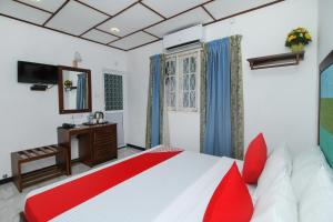 a bedroom with a red and white bed and a mirror at Slnco Villa in Katunayake