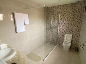 IvatoにあるFLY INN Madagascar HOTEL - Navette GRATUITE H24 - à 300m de l'Aéroport International Ivato-Antananarivoのバスルーム(シャワー、洗面台、トイレ付) +25枚の写真