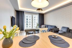 グダニスクにある3ROOMS UNO 4 Apartmentのリビングルーム(テーブル、ソファ付)