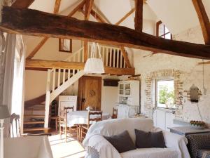 a living room with a couch and a table at La ferme aux grenouilles in Saint-Josse