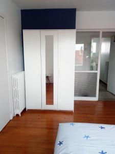 a bedroom with white cabinets and blue stars on the bed at Charmant F2 avec vue, proche centre in Clermont-Ferrand