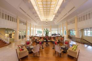 a lobby with chairs and tables in a building at Dheva Mantra Resort in Kanchanaburi