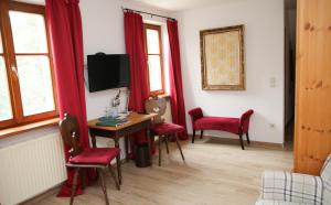 a room with a desk and red chairs and a tv at Gasthof Schloßbräu Lintach in Freudenberg