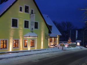 a yellow building with lights on the side of it at Gasthof Schloßbräu Lintach in Freudenberg