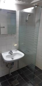 La salle de bains est pourvue d'un lavabo et d'une douche en verre. dans l'établissement Kimstay 9, à Séoul
