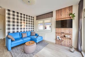 sala de estar con sofá azul y TV en Haus Pamir _ Fewo 24 en Cuxhaven