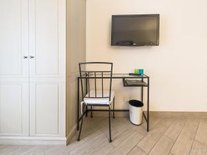 a desk with a chair and a tv on a wall at Hotel San Pietro Palace in Finale Ligure