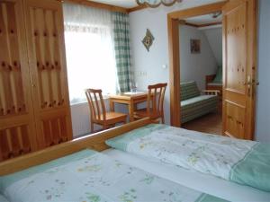 een slaapkamer met een bed en een tafel en stoelen bij Zukaunighof in Diex