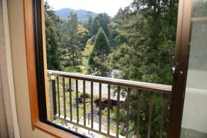 una ventana con vistas a un bosque en Miyajima Morinoyado en Miyajima