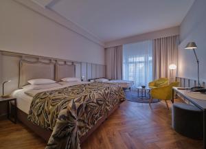 um quarto de hotel com uma cama grande e uma secretária em Classik Hotel Alexander Plaza em Berlim