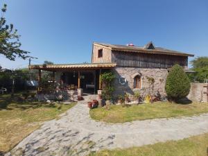 una pequeña casa de piedra con un camino de piedra delante de ella en Robinson Stonehouse en Babakale