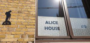 a glass door with a nice house sign next to a brick wall at Holiday Home Alice House in Ieper