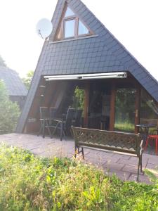 eine Bank vor einem Gebäude mit einem Dach in der Unterkunft Feriendorf Freilingen 151 A in Blankenheim