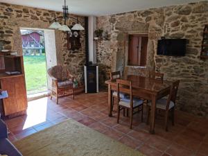 - une salle à manger avec une table, des chaises et une télévision dans l'établissement Casa Eido Vello, à Mos