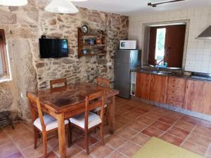 a kitchen with a wooden table and a refrigerator at Casa Eido Vello in Mos