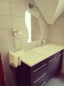 Főnix Apartmanház في Nagypáli: حمام مع حوض ومرآة