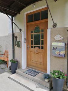 une porte d'entrée d'une maison avec deux plantes en pot dans l'établissement Hotel Garni Steiermark, à Bad Reichenhall