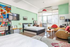 a bedroom with a bed and a couch and a tv at Art Station x Residence in Tainan