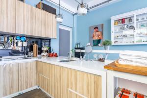 a kitchen with blue walls and wooden cabinets at Art Station x Residence in Tainan