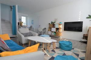 a living room with a couch and a table at Appartement moderne avec terrasse à 500m de la mer in Courseulles-sur-Mer