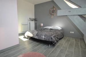 a bedroom with a bed with a black and white comforter at Appartement moderne avec terrasse à 500m de la mer in Courseulles-sur-Mer