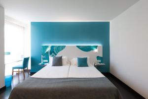 a bedroom with a large bed with a blue wall at Hotel Concordia Barcelona in Barcelona