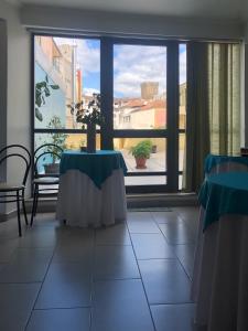 a room with two tables and a large window at Hotel Termas in Chaves