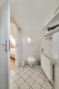 クックスハーフェンにあるHaus Pamir _ Fewo 26の白いバスルーム(トイレ付)、ベッド1台が備わります。