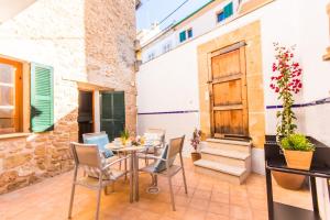 Un patio con una mesa y sillas en un edificio. en Ideal Property Mallorca - Barbera, en Alcudia