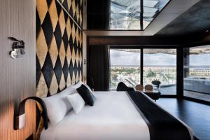 a bedroom with a bed and a large window at H Hotel & SPA - Adults Only in St. Julianʼs