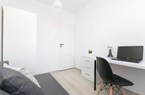 a bedroom with a desk with a laptop computer on it at Rooms4Less in Gdańsk