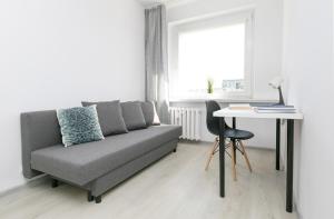 a living room with a couch and a table at Rooms4Less in Gdańsk