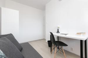 a room with a desk and a couch and a chair at Rooms4Less in Gdańsk