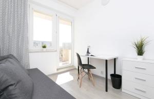 a white room with a desk and a chair at Rooms4Less in Gdańsk +18 photos