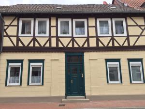 una casa con una puerta verde y ventanas en Ferienwohnung Kuckucksnest, en Helmstedt