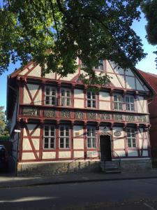 un viejo edificio rojo y blanco al lado de una calle en Ferienwohnung Kuckucksnest, en Helmstedt