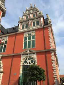 un edificio rojo con una torre encima en Ferienwohnung Kuckucksnest, en Helmstedt