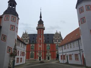 duży czerwony budynek z wieżą zegarową w obiekcie Ferienwohnung Kuckucksnest w mieście Helmstedt