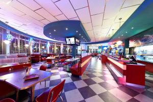 a restaurant with tables and chairs and a bar at Road House Hotel in Paderborn