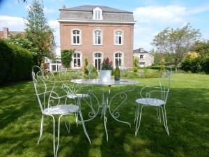 a table and chairs in front of a house at Le Chant du coucou in Huy