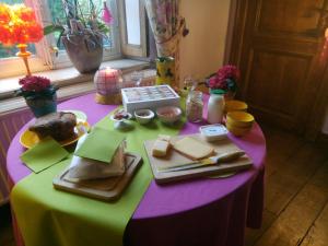 a table with a purple and green table cloth with food on it at Le Chant du coucou in Huy