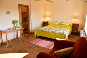 a bedroom with a bed and a table and a couch at Le Chant du coucou in Huy