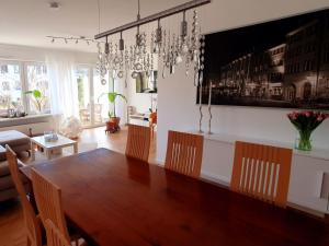 comedor con mesa de madera y lámpara de araña en Haus 15, en Offenburg
