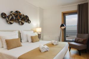 um quarto com uma cama, uma cadeira e uma janela em Oriente 57 Housing by APT IIN em Lisboa