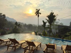 a view of a pool with chairs and the sunset at Mai Chau Sunset Boutique Hotel in Mai Châu