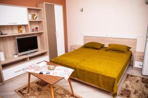 ein kleines Schlafzimmer mit einem Bett und einem Tisch in der Unterkunft Apartament Cora Centru Pitesti in Piteşti