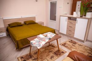 a small bedroom with a bed and a table at Apartament Cora Centru Pitesti in Piteşti