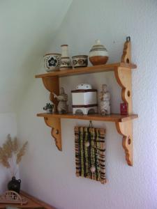 a wooden shelf on a wall with pottery on it at Ferienwohnung Teubner in Bockau