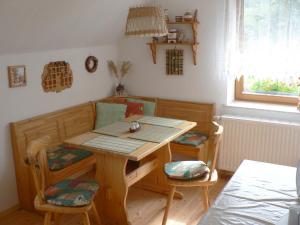 uma mesa de madeira e cadeiras num quarto com uma mesa em Ferienwohnung Teubner em Bockau