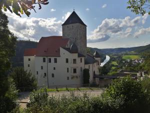 a castle with a tower and a river in the background at Ferienwohnung Pagel in Riedenburg